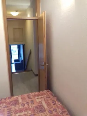 a bedroom with a door leading into a room with a mirror at City View Apartment in Fojnica