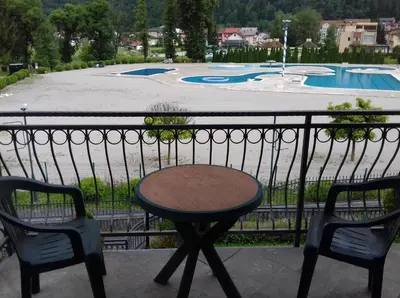 a table and two chairs on a balcony with a pool at City View Apartment in Fojnica
