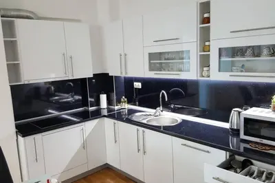a kitchen with white cabinets and a sink at Fantasy apartment Tuzla in Tuzla