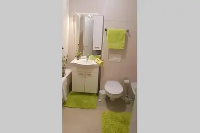 a bathroom with a sink and a toilet and a mirror at Fantasy apartment Tuzla in Tuzla