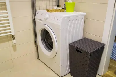 a washer and dryer in a corner of a room at Fantasy apartment Tuzla in Tuzla
