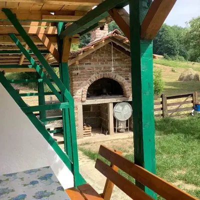 a brick pizza oven with a green roof at Apartman Bosanska Avlija-Muzej- in Visoko