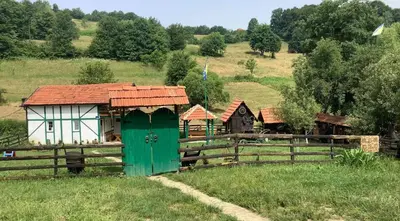 a small house in a field next to a fence at Apartman Bosanska Avlija-Muzej- in Visoko