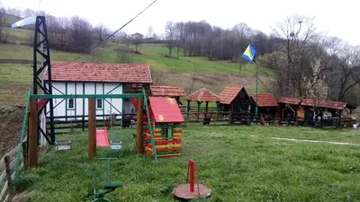 a group of wooden play structures in a field at Apartman Bosanska Avlija-Muzej- in Visoko