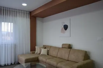 a living room with a couch and a glass table at ATOS Centar in Čelinac