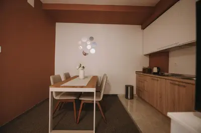 a kitchen with a table and chairs in a room at ATOS Centar in Čelinac