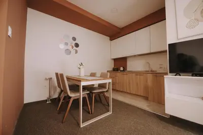 a kitchen with a table and chairs and a television at ATOS Centar in Čelinac