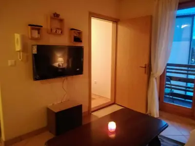 a living room with a table and a television and a candle at Apartman SARA Babanovac Vlašić in Travnik