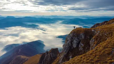 a person standing on the top of a mountain with clouds at Apartman SARA Babanovac Vlašić in Travnik