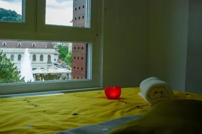 a bedroom with a bed with a heart and a window at Apartman Amor in Tuzla