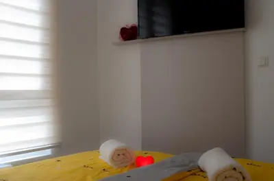 a bedroom with a bed with towels on it at Apartman Amor in Tuzla