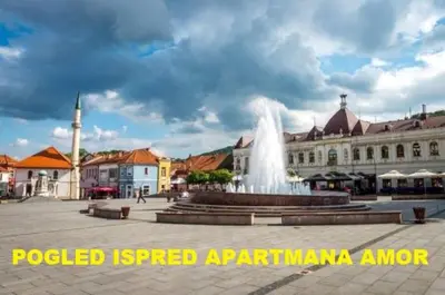 a fountain in the middle of a square with buildings at Apartman Amor in Tuzla