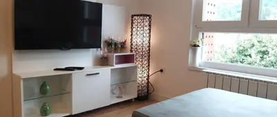 a living room with a flat screen tv on a wall at Apartman Amor in Tuzla