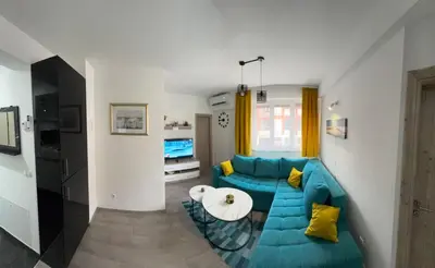 a living room with a blue couch and a table at Apartman 