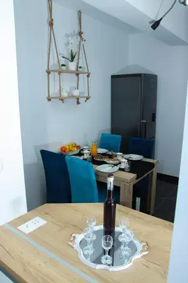 a table with a bottle of wine and glasses on it at Apartman 