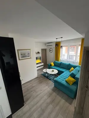 a living room with a blue couch and a table at Apartman 
