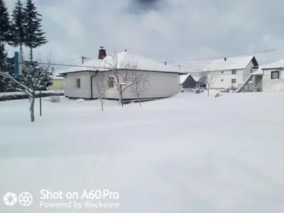 a snow covered yard with houses in the background at kuća za odmor Katy in Kupres