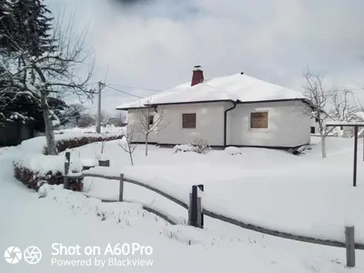 a house covered in snow in a yard at kuća za odmor Katy in Kupres