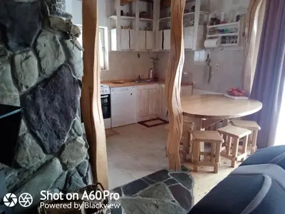 a kitchen with a table and a stone wall at kuća za odmor Katy in Kupres