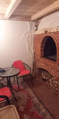 a room with a brick fireplace with a table and chairs at kuća za odmor Katy in Kupres