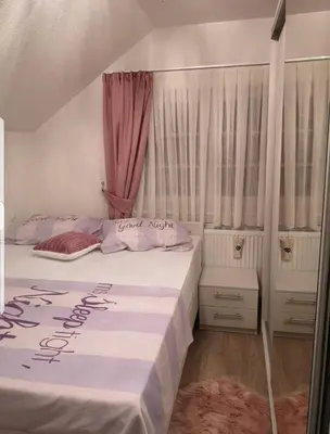 a bedroom with two beds with pink curtains at Kuća za odmor ANA in Kupres