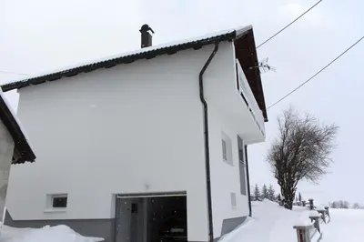 a building covered in snow with a bird on the roof at Kuća za odmor ANA in Kupres