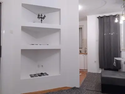 a white wall with shelves in a living room at Apartman CENTAR in Banja Luka