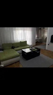 a living room with a green couch and a coffee table at Dan i noc in Banja Luka