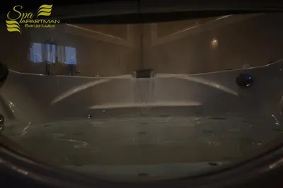 a white bath tub with water pouring into it at Spa Apartman Banja Luka in Banja Luka