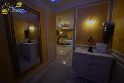 a bathroom with a large mirror and a dresser at Spa Apartman Banja Luka in Banja Luka