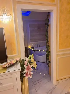 a bathroom with a tub and a vase of flowers at Spa Apartman Banja Luka in Banja Luka