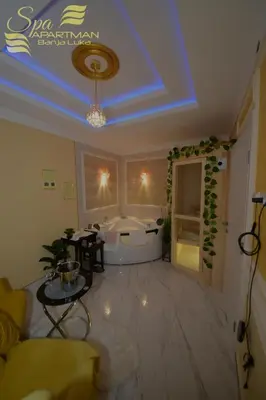 a large living room with a tub and a table at Spa Apartman Banja Luka in Banja Luka