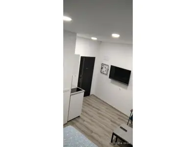 a living room with white walls and wooden floors at Slatka Tajna in Banja Luka
