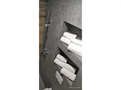 a bathroom with white towels on a shelf at Slatka Tajna in Banja Luka