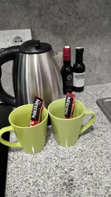two green cups on a kitchen counter with a tea kettle at Slatka Tajna in Banja Luka