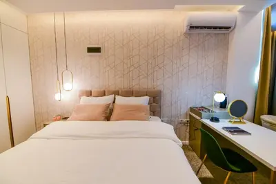 a bedroom with a white bed and a desk and a desk at Hotel City View in Prnjavor