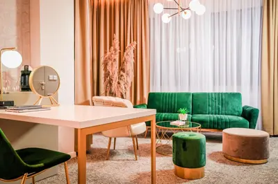 a living room with a green couch and a table at Hotel City View in Prnjavor