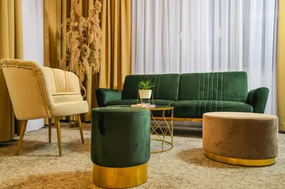 a living room with a green couch and a chair at Hotel City View in Prnjavor