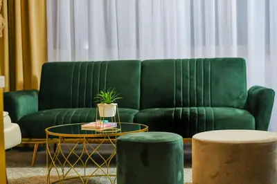 a living room with a green couch and a table at Hotel City View in Prnjavor