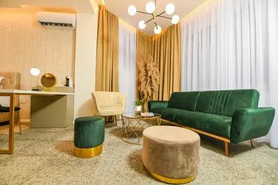 a living room with a green couch and a table at Hotel City View in Prnjavor