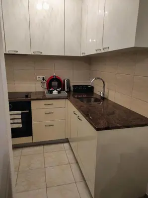 a kitchen with white cabinets and a sink and a stove at Apartman HANA in Travnik