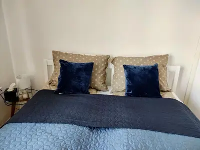 a bedroom with a bed with blue sheets and pillows at Apartman HANA in Travnik