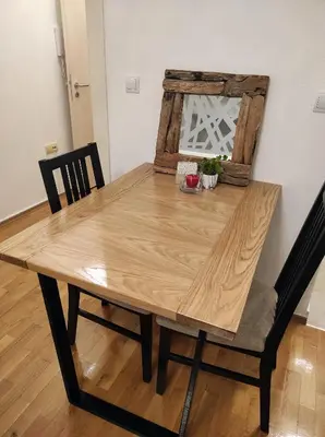 a wooden dining table with two chairs and a wooden table at Apartman HANA in Travnik