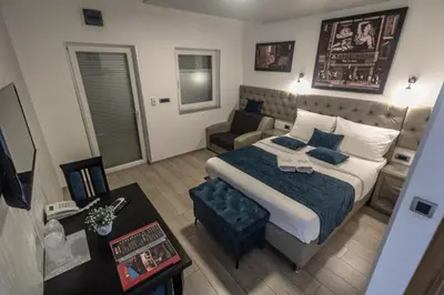 a bedroom with a large bed and a couch at Motel Atos Bungalovi in Nova Topola