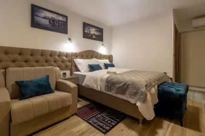 a bedroom with a large bed and a couch at Motel Atos Bungalovi in Nova Topola