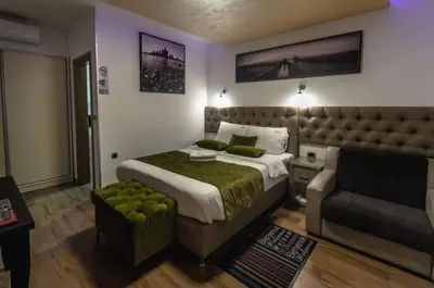 a bedroom with a bed and a chair and a couch at Motel Atos Bungalovi in Nova Topola