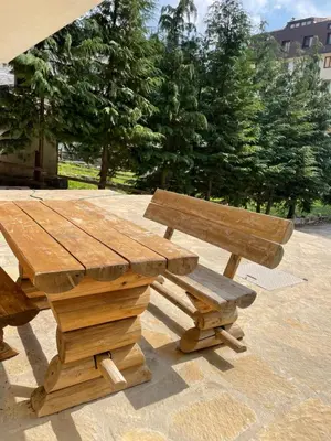 a wooden picnic table and bench in a park at Apartmani Megara Vlasic in Šišava