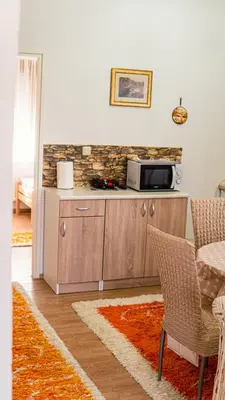 a kitchen with a microwave and a table and chairs at apartment HOME in Bihać
