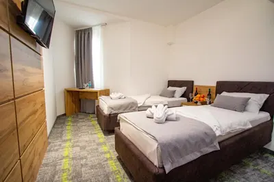 a hotel room with two beds and a flat screen tv at Hotel Grand in Banja Luka