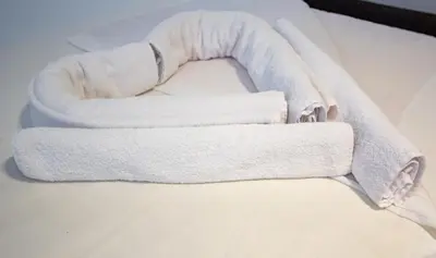 a couple of towels sitting on top of a bed at Hotel Grand in Banja Luka